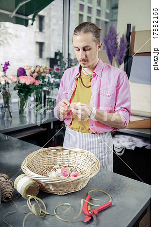 Attentive young florist working in modern studio Attentive young florist working in modern studio 47332166