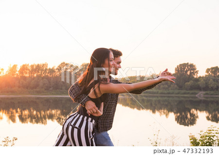 Romantic, social dance and people concept - young couple dancing a tango or bachata near the lake Romantic, social dance and people concept - young couple dancing a tango or bachata near the lake 47332193
