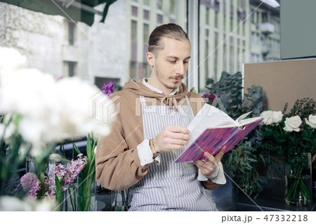 Serious gardener reading article about modern plants 47332218