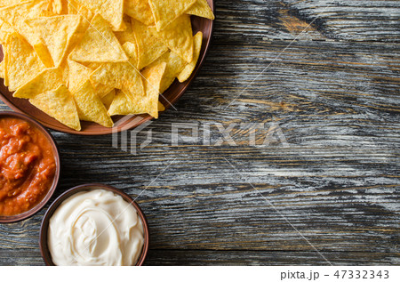 Nachos corn chips, spicy tomato and cheese sauces. 47332343