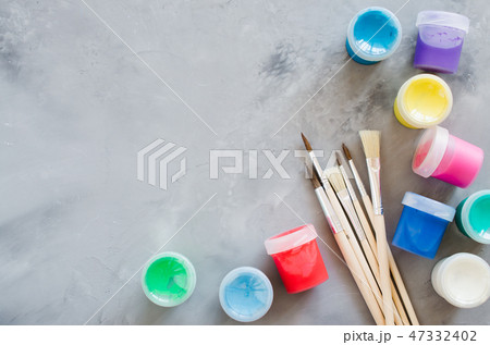 Set of clean paint brushes and multicolor paints. 47332402