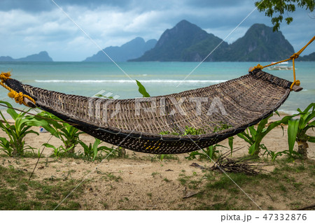 Traditional braided hammock in the shade with tropical island in the background 47332876