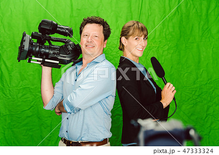 Crew of reporter and cameraman posing in the studio 47333324