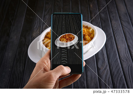 Hand with phone. Blogger making photo of food. 47333578