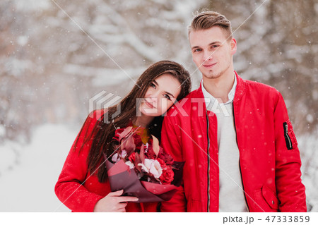 A date of lovers with my park in the winter. A bouquet of red flowers, walk, hug, kiss, laugh in a 47333859