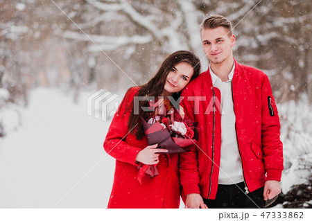 A date of lovers with my park in the winter. A bouquet of red flowers, walk, hug, kiss, laugh in a 47333862