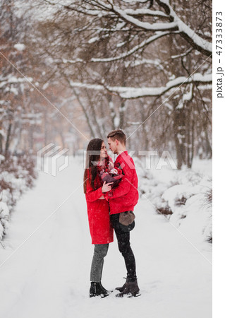A date of lovers with my park in the winter. A bouquet of red flowers, walk, hug, kiss, laugh in a 47333873