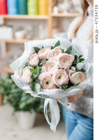 beautiful fresh cut bouquet of mixed flowers in woman hand. the work of the florist at a flower shop 47334739