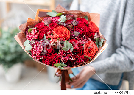 beautiful fresh cut bouquet of mixed flowers in woman hand. the work of the florist at a flower shop 47334792