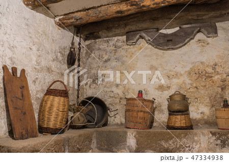 Basement old house wooden beams, antique household, carboy demijohn, stewpot, plank, Wicker basket 47334938