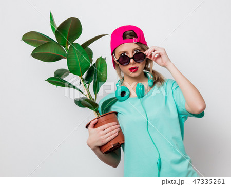 girl in pink cap and blue t-shirt with green plant girl in pink cap and blue t-shirt with green plant 47335261