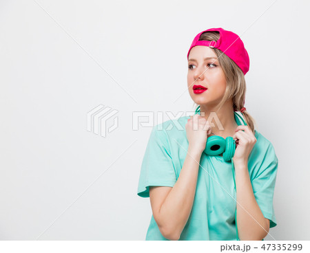 girl in pink cap and blue t-shirt with headphones girl in pink cap and blue t-shirt with headphones 47335299