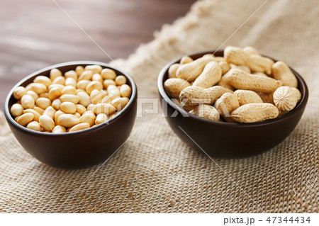 Peanuts in the shell and peeled closeup in a cup Peanuts in the shell and peeled closeup in a cup 47344434
