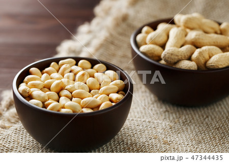 Peanuts in the shell and peeled closeup in a cup 47344435