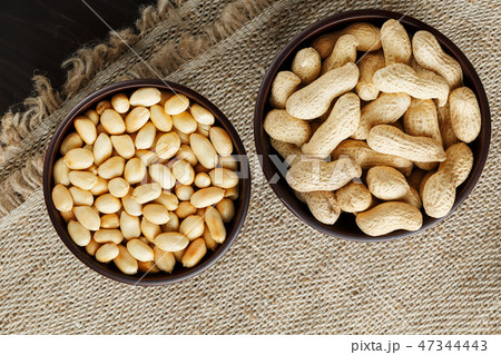 Peanuts in the shell and peeled closeup in a cup Peanuts in the shell and peeled closeup in a cup 47344443