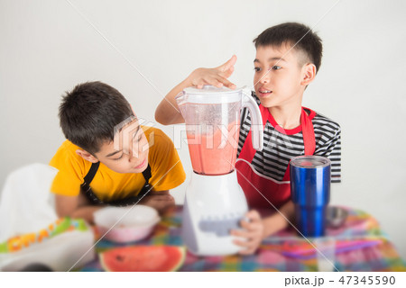 Little boys blend water melone juice by using blender at home Little boys blend water melone juice by using blender at home 47345590