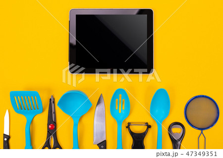 top view of the tablet and kitchen utensils next to it isolated on a yellow background top view of the tablet and kitchen utensils next to it isolated on a yellow background 47349351