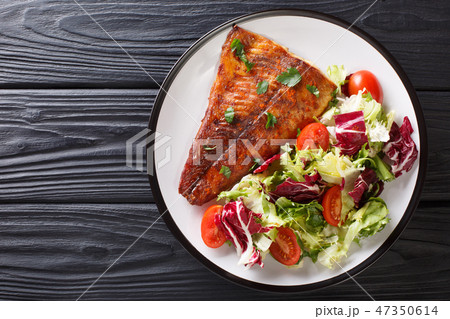 Serve baked pike fillet and fresh salad close-up Serve baked pike fillet and fresh salad close-up 47350614