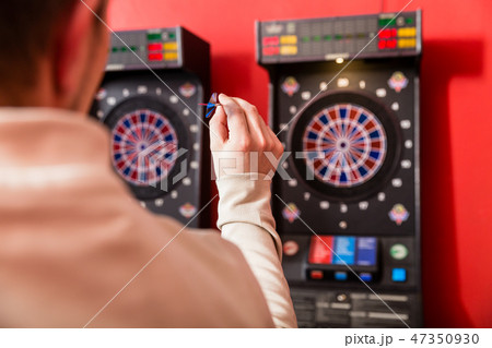Man aiming at dartboard 47350930