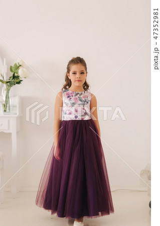 Happy child female in purple dress. Beautiful makeup and hairstyle 47352981
