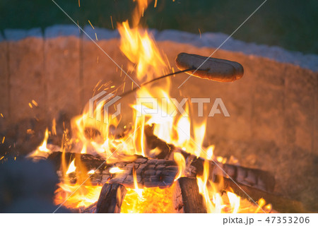 Roasting sausages on the campfire 47353206