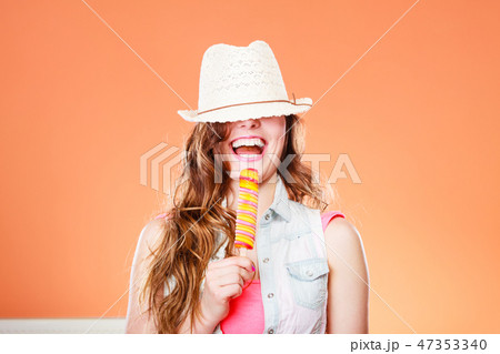 woman in summer hat eating ice pop cream woman in summer hat eating ice pop cream 47353340
