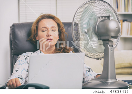 Woman suffers from heat in the office or at home 47353415