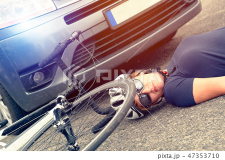 Female cyclist lying on the road 47353710