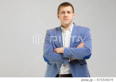 young man in a jacket folded arms isolated on light background young man in a jacket folded arms isolated on light background 47354074