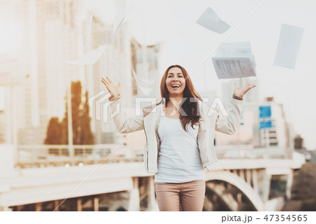 The girl throws paper on the background of houses 47354565