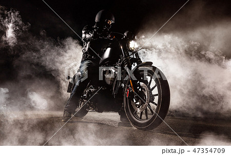 Dark motorcycle driver in fog Dark motorcycle driver in fog 47354709