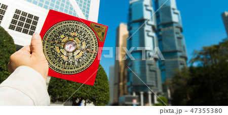 Feng Shui Master show FengShui Compass and turn direction to Force Energy, He wear black shirt to check North South West East for Luck and Prosperity to Design Building on Wind Water elements Signs 47355380