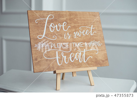 The close-up photo of the wooden plaque with the signs Love to the wedding standing on white The close-up photo of the wooden plaque with the signs Love to the wedding standing on white 47355873