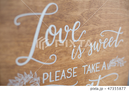 The close-up photo of the wooden plaque with the signs Love to the wedding standing on white 47355877