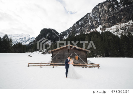 Beautiful young couple in winter mountains. Winter walk of lovers. Man hugging woman Beautiful young couple in winter mountains. Winter walk of lovers. Man hugging woman 47356134