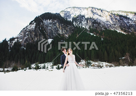 Beautiful young couple in winter mountains. Winter walk of lovers. Man hugging woman Beautiful young couple in winter mountains. Winter walk of lovers. Man hugging woman 47356213