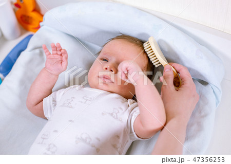 Mother combing hair for her infant baby. Concept of newborn care. 47356253