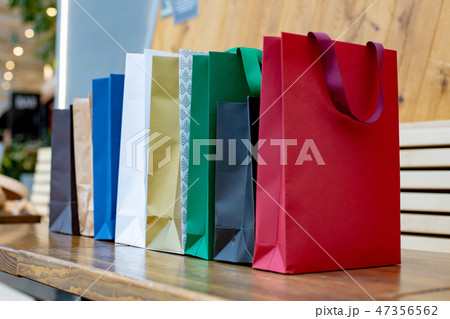 Colourful paper shopping bags on wooden background Colourful paper shopping bags on wooden background 47356562