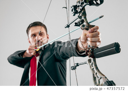 Businessman aiming at target with bow and arrow, isolated on white background Businessman aiming at target with bow and arrow, isolated on white background 47357572