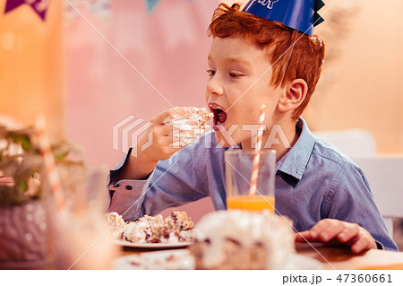 Hungry red-haired boy eating tasty birthday cake Hungry red-haired boy eating tasty birthday cake 47360661