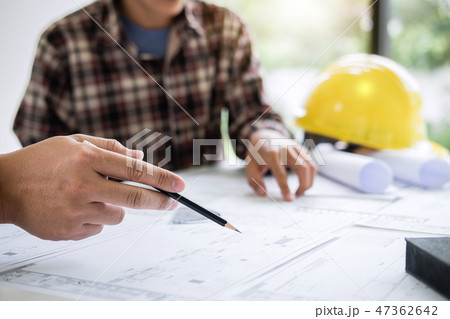 Construction engineering or architect discuss a blueprint while 47362642