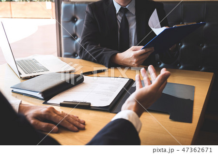 Employer or recruiter holding reading a resume during about his Employer or recruiter holding reading a resume during about his 47362671