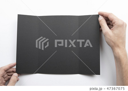 Mens hands holding black booklet 47367075
