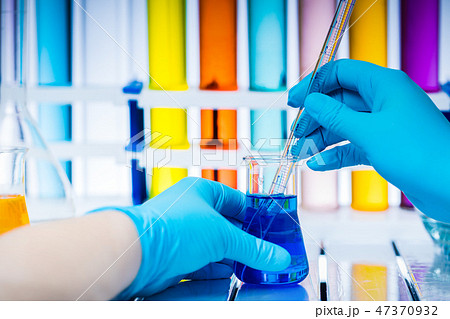 Laboratory worker analyzes chemical liquid in a flask. Laboratory worker analyzes chemical liquid in a flask. 47370932