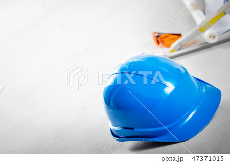 Hard hat, glasses and blueprints at construction site. Hard hat, glasses and blueprints at construction site. 47371015