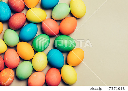 Couple of dyed eggs laying on a creamy background. 47371018