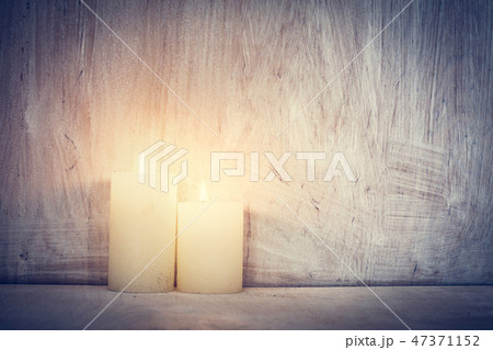 Chistmas candle glowing on rustic wooden wall background. 47371152