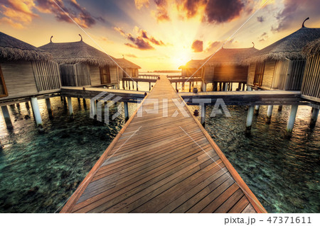 Wooden jetty and water villas. Maldives island resort at sunset Wooden jetty and water villas. Maldives island resort at sunset 47371611