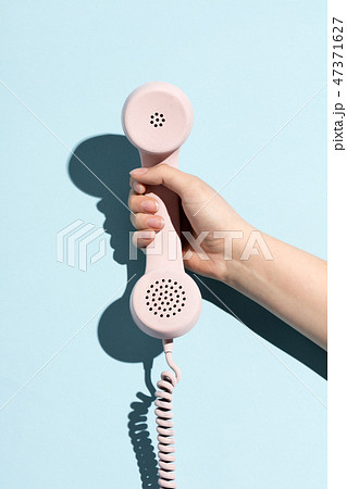 Woman's hand holding a pastel telephone 47371627