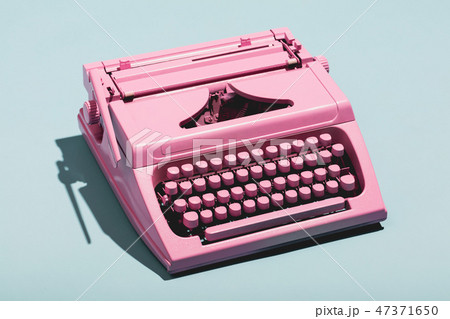 Pink typewriter on a blue pastel background. 47371650